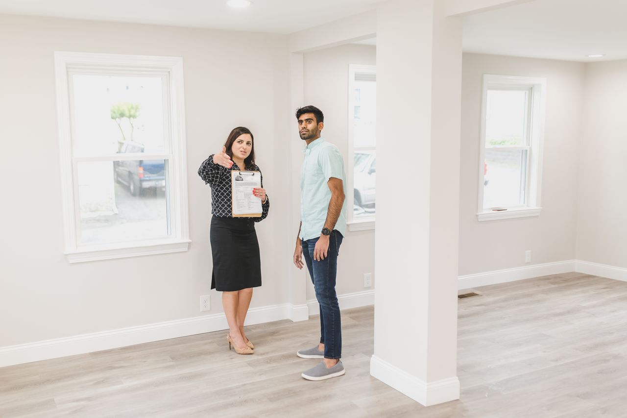 Home A real estate agent showing a potential buyer the interior of a new home.
