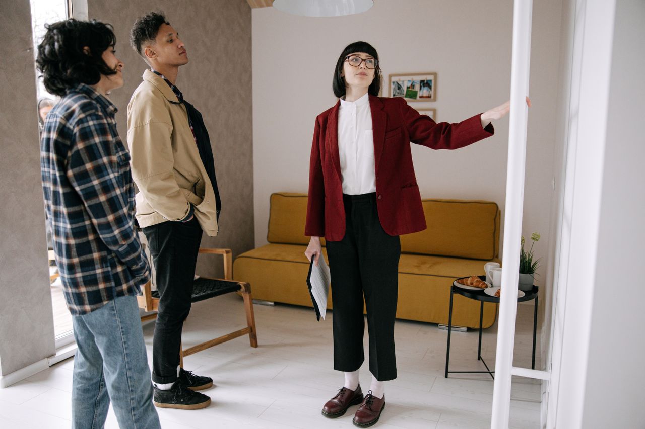 Home Realtor guiding potential buyers through a stylish apartment viewing.